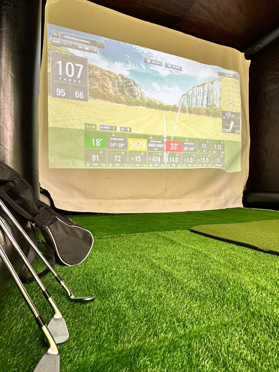 Golf clubs and simulator screen inside the Golf Anywhere tent